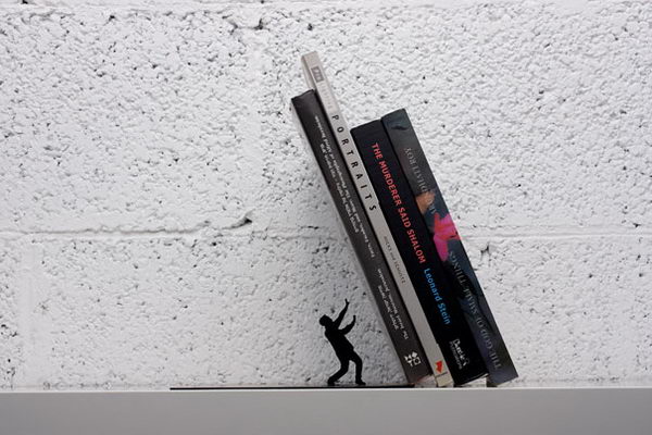 Falling Bookend. The heavy books appear to almost crush the handsome little man, but don't worry - the sturdy book end will keep your books tidy and upright.