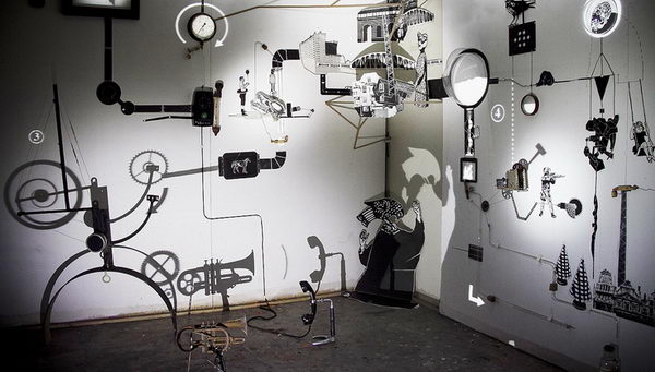 Rube Goldberg Style Installation Art, This is an art installation that combines Rube Goldberg logic with light, shadows, wooden shapes, found objects, and full motion video.