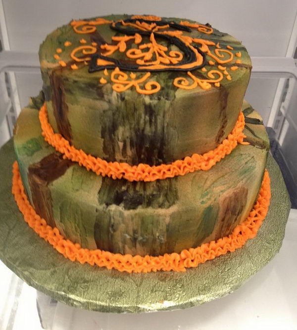 Camouflage wedding cake with initial piped in frosting on top tier.