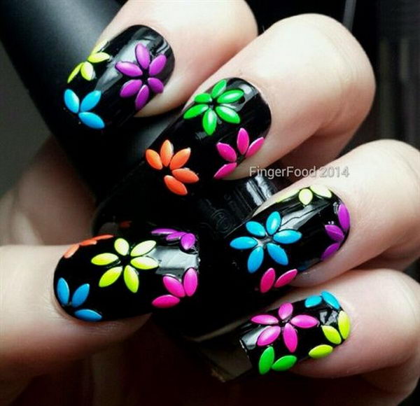 3D Nail Art with Colored Flowers on Black Background, 3D nail art is a technique for decorating nails that creates three dimensional designs.