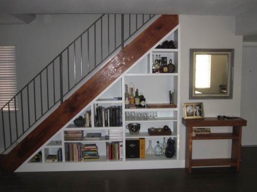 under stairs bookcase. The space under a staircase can be used to keep everyday clutter out of the way.