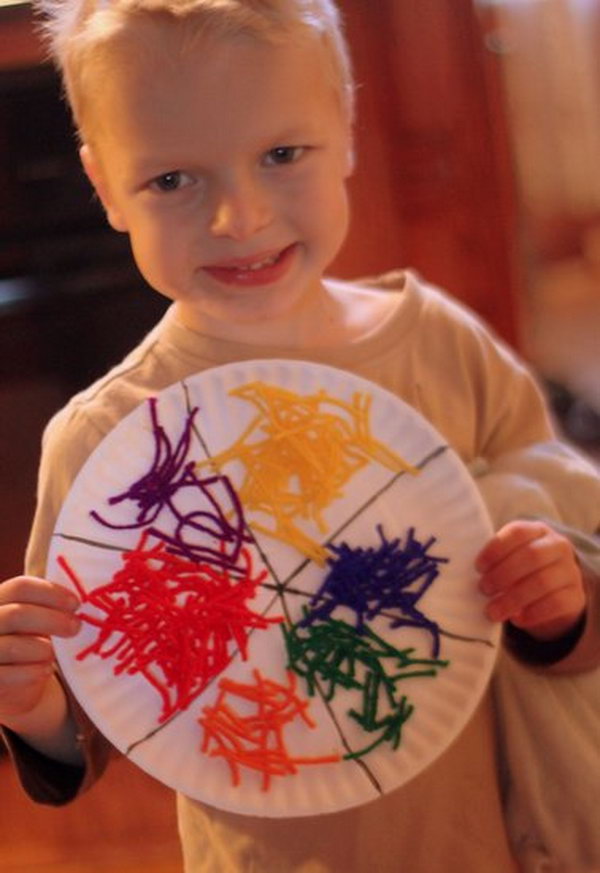 Glue the yarn to the paper plate and make a simple yarn color wheel for kids. 