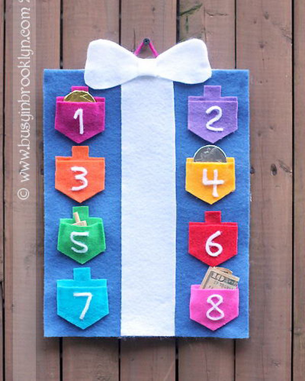 A countdown-to-Hanukkah calendar with draidel pockets for each night. The pockets are perfect little holders for Chanukah chocolate coins, the real (green) stuff, draidels and little gifts.  