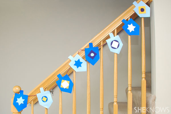 Decorate the railing and mantel with the felt dreidel banner. 