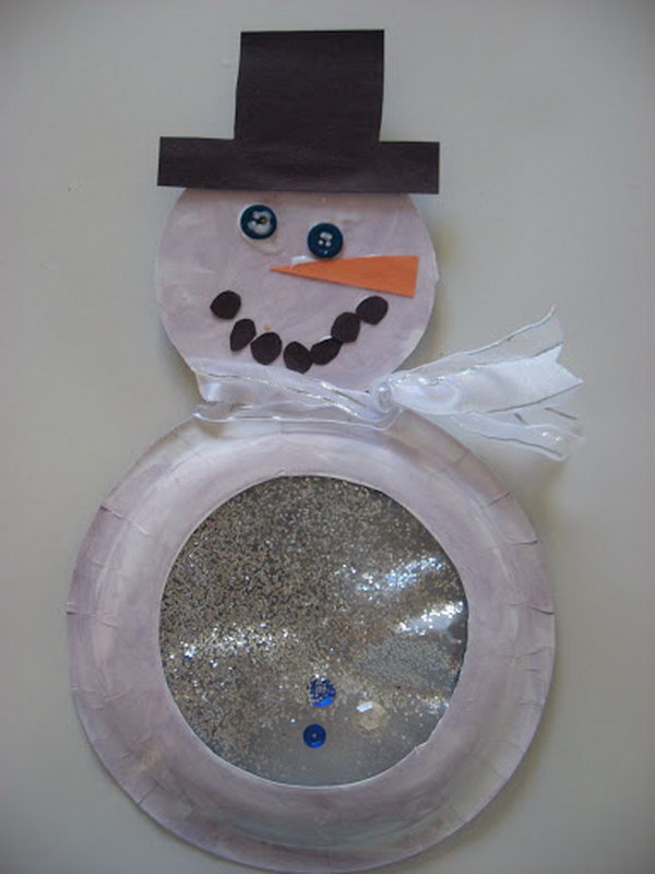 Snowglobe snowman made with paper plate, buttons, sparkles and ribbon. 