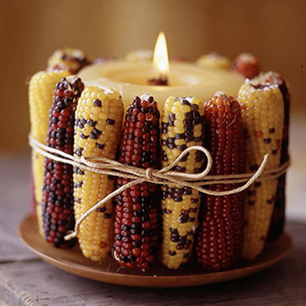 Alternate light and dark colored ears of Indian corn around a fat cream colored pillar candle and tie the whole thing with some rustic string. 