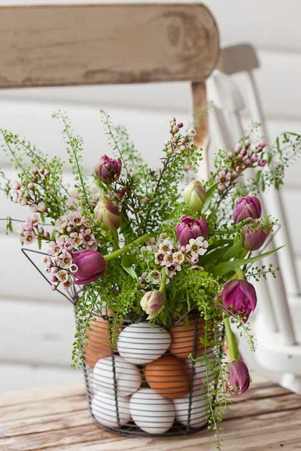 Easter Centerpiece with Eggs and Flowers. Place flowers in a vase inside wire basket and arrange plastic eggs in between. It's perfect for an elegant Easter table display. 