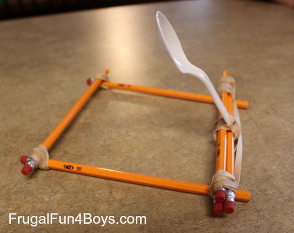 Pencil Catapult. This catapult is built out of unsharpened pencils, rubber bands, and a plastic spoon. The process of making is so easy, your kids can make it by themselves just according to this picture.