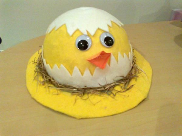 Chicken Styled Easter Bonnet. This adorable Easter bonnet with chicken style is made up of yellow and white craft paper. Glue the eye and mouth, then put some straws to decorate it.