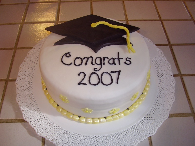 Nurse Graduation Cake. This nurse graduation cake has a graduate's cap at the top, a circle of pearl candies at the bottom as well as some floral decoration at the side for beautiful garnishment. The graduate must adore this sweet and elegant graduation cake.