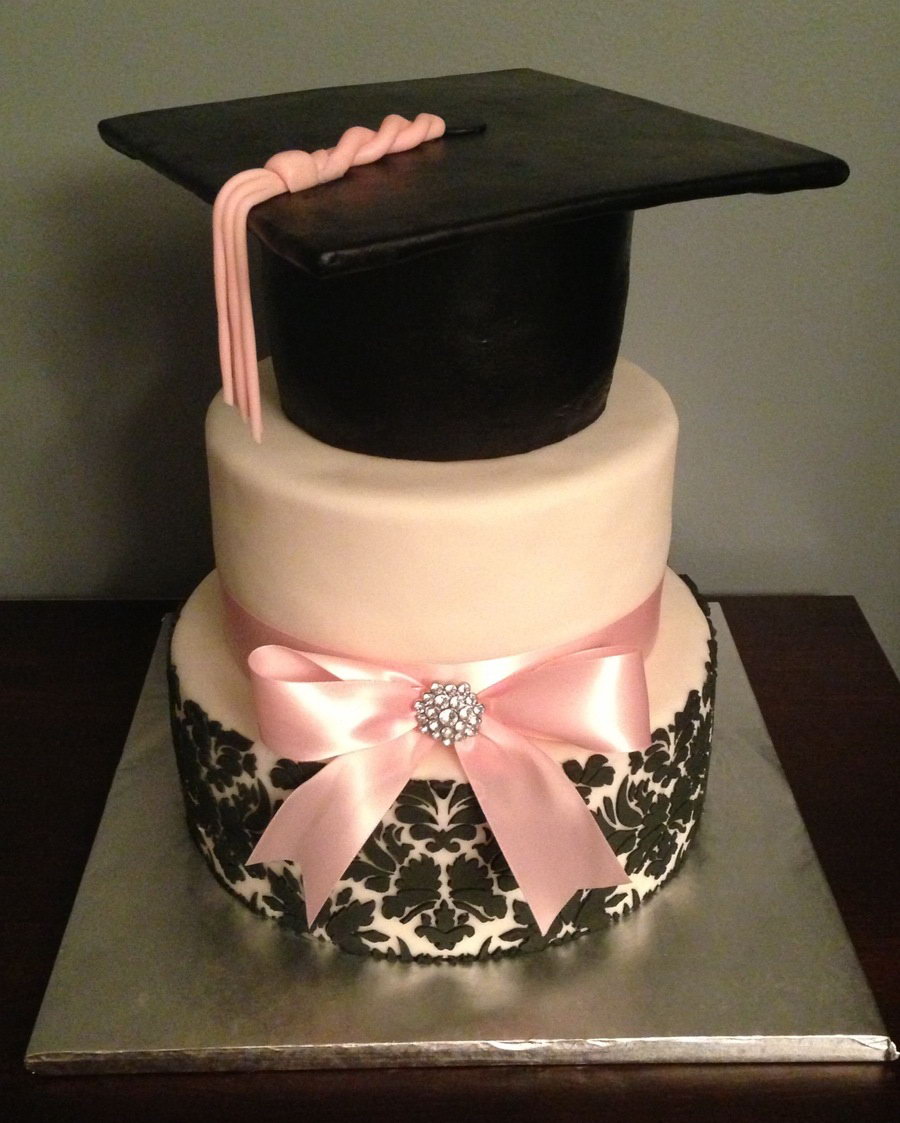 Girly Graduation Cake. Herald the graduate's academic triumph with such a cake for a girl. The topper part of the cake is made from cake cardboard covered in fondant. It has satin ribbon with jewel detail for pretty decoration.