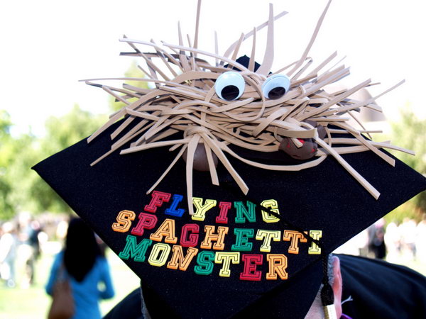 FSM Graduation Cap. This flying spaghetti monster graduation cap is created in a strange shape like a pirate fish with cue eyes. Add some colorful alphabets for its beautiful decor.