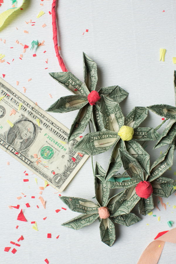 DIY Money Necklace. It's so fantastic to decorate the graduate with this DIY money necklace. Use floral wire to secure the folded bills. Use tissue paper to create the centerpiece. Arrange floral bills on the wire in a beautiful design as you like.
