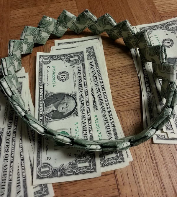 Cash Headband for Graduation. It's boring to send graduate money using envelopes. Try this fun idea to pack your cash as a gift for the graduate. Fold the dollar bill. Take the long end and fold the edge to meet the middle. Assemble and insert one into the other to create the headband.