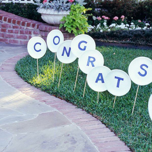 Wooden Sign Graduation Party Decor. Cut out letters and glue to paper plates, attach wooden dowels and stick into the lawn. This graduation decor serves as a direction guide for your party and it can also cut down your party expenditure.