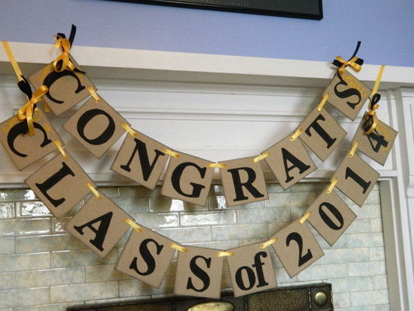 Graduation Banner Decoration. This handmade banner uses sunflower yellow acrylic paint for the swirl accents and ribbons bows of the same color to coordinate with the theme of the party to create a unique and vintage style.