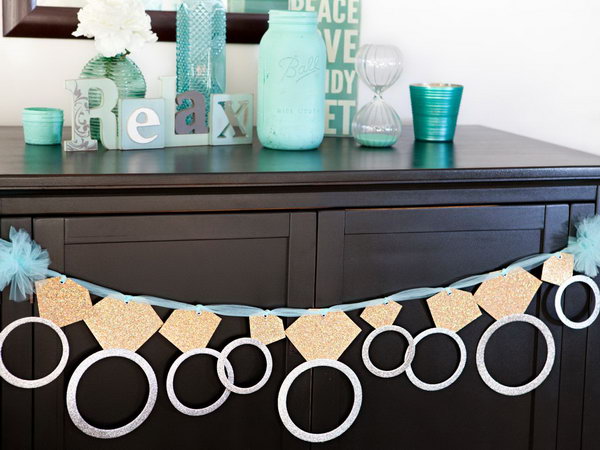 Glittering Ring Banner. This gorgeous diamond ring banner is perfect for a graduation party with its sweet outlook. Attach each circle to the diamond using adhesive scrapbooking. Insert the ribbon or tulle through eyelet hole to hang and celebrate.