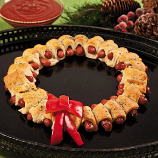 Mini Sausage Wreaths. Cutting prepared pizza into 32 pieces, wrap one strip of dough around mini sausage. Bake until the color turns gold. Add rosemary topped butter on top of the srescent-wrappend sausages. Display in a wreath shape and add the bow made of red pepper for decoration to celebrate your Christmas party. 