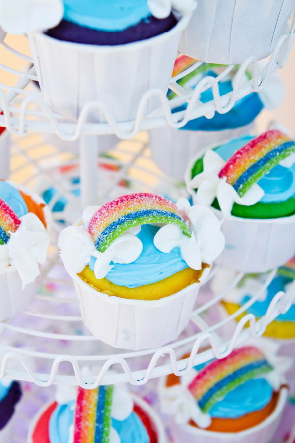 Serve your party with these colorful rainbow cupcakes. Put together all the rainbow cupcakes along the shelf. Decorate the cupcakes with sour rainbow candy and frosting clouds.