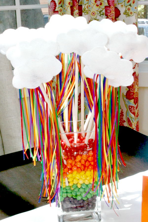 Fill the glass jar with candies layers upon layers. Add some decorations for beautiful outlook design such as white cute clouds and colorful ribbons on sticks. It can light up your party design style.