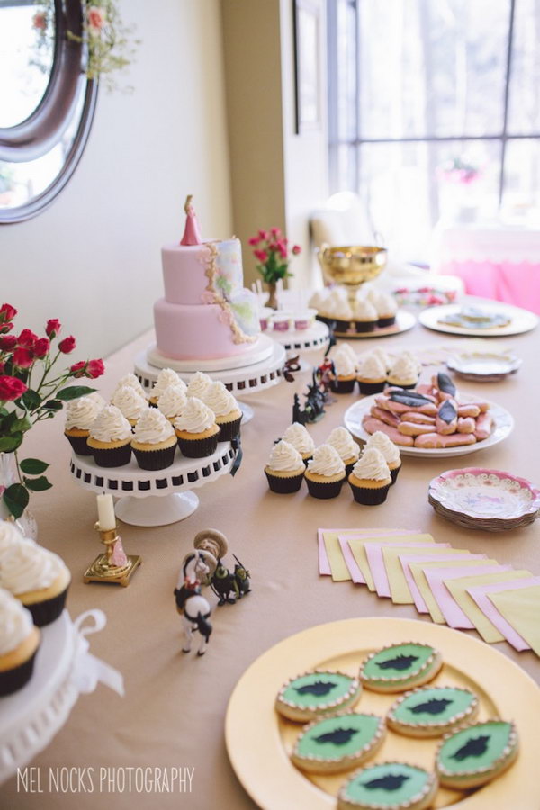 Maleficent Princess Aurora Party Idea. I really adore this party design with a combination of darling cake, hanging crest adorned with floral garland, Maleficent cookies, floral crown and spool of thread cake pops to create a whimsically soft style and floral design flavor.