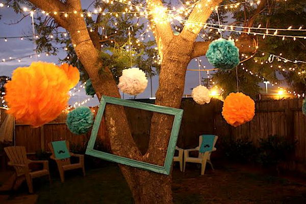 Lights and Tissue Paper Poms. This summer party features the elegant Christmas lights from trees and tissue poms on the strands to create an elegant decor. This decoration is fantastic to get everything dolled up for the summer party.