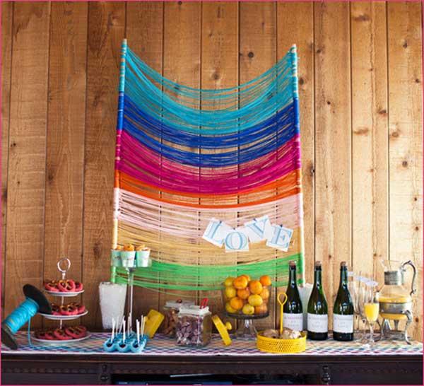 Colorful Yarn Backdrop. This glamorous backdrop decor will make a perfect starting point for your wedding ceremony. The yarn strung across your sweet table with the love word tied into it creates a sweet festive flavor.