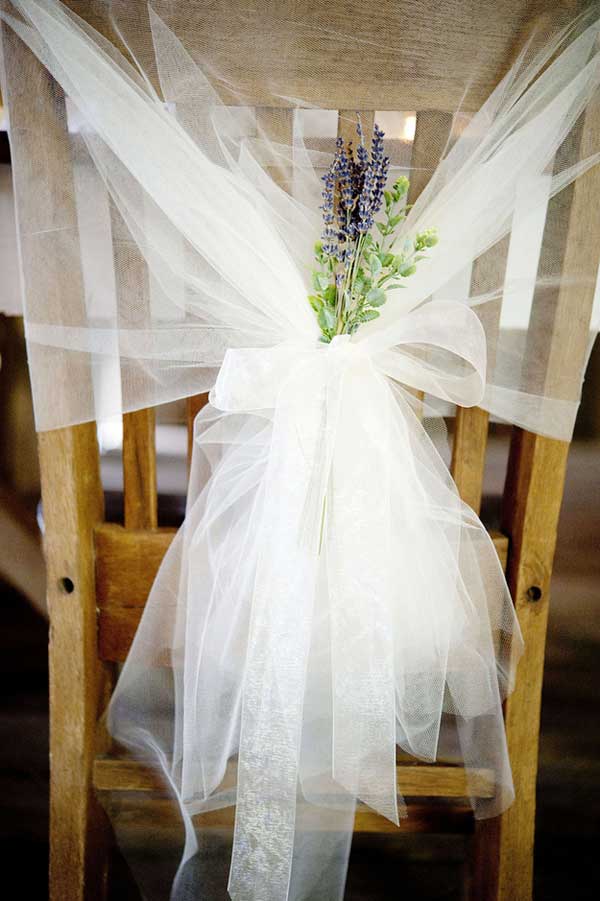 Lavender and Tulle Chairbacks. Tie lengths of ethereal tulle to the back of your chairs and attach colorful flowers such as lavender to match your wedding theme. I really adore this chair decoration for its romantic and dreamy style for wedding ceremony.