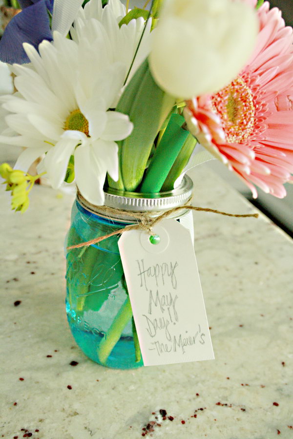 Flower Jar for May. Grab some ribbon, twine a little tag. Fill your mason jars with water, make a beautiful arrangement of flowers to your imagination. Place the screw band on the jar. You'll get this artistic flower jar for May in beautiful design.