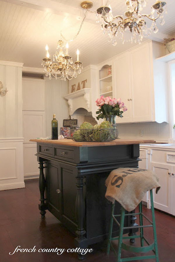  French country kitchen.  Strong contrasts such as the one between black and white are always beautiful. Black-and-White Island, and custom stools bring weight to the kitchen's white island. 