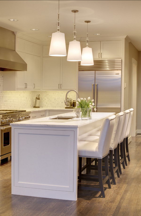  A Bright Spot.An all in white island with simple lines, echoes this kitchen's white pendants and white elegant custom-made chairs. Stainless steel appliances add to very stylish and morden look. 