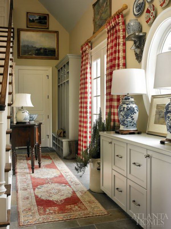  Farmhouse mud room. Classic blue-and-white relics ecco other traditional decors like an Oushak rug, mahogany buffet and red-and-white check curtains. 