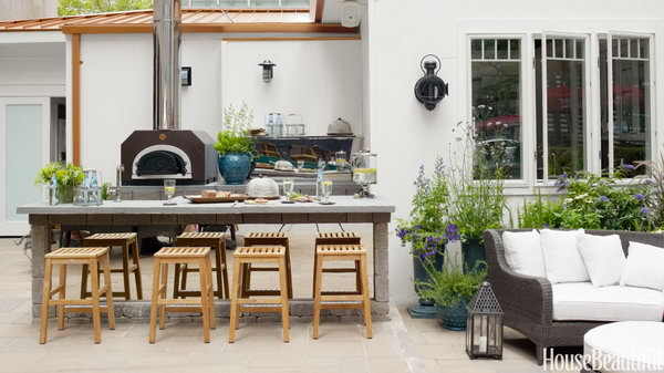 Designer Mick De Giulio used a variety of colors, shapes and texture of stone to give this outdoor kitchen an organic feeling. All of the appliances are from Belgard Hardscapes, from super strong paves to the island topped with bluestone.