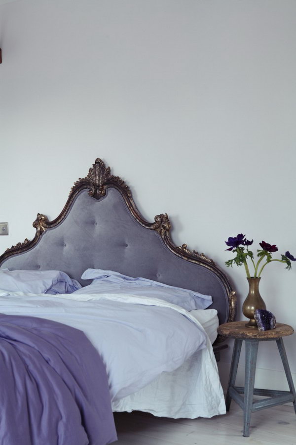 Eye Catching French Headboard: In the master bedroom, a French headboard is reupholstered in a soothing purple gray velvet that blends well with Farrow & Ball Great White-painted walls. 