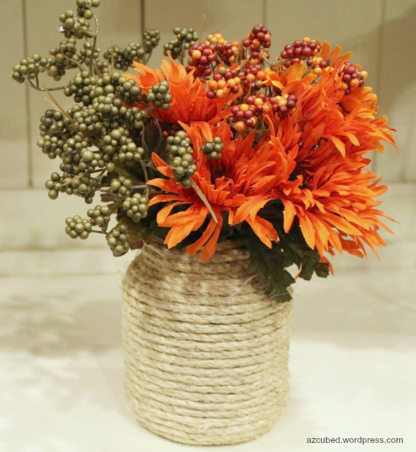 DIY Rope-Wrapped Vase. A vase, some ropes, hot glue gun and hot glue are all you need to make this rope-wrapped vase. It will be an amazing table centerpiece with some fall flowers and leaves in.