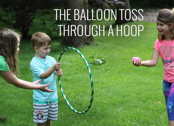 Balloon Toss through a Hoop. Ask one kid to hold the hula-hoop and the other kid try to toss the water balloon through the hoop. It's challenging yet interesting.