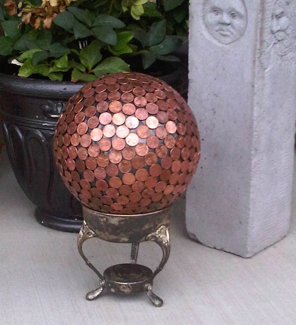 Penny Gazing Ball Yard Art.   Add year-round color to your garden with  fabulous art projects you can make yourself. This gazing ball made with pennies will add more style to your landscape. See how to do it  