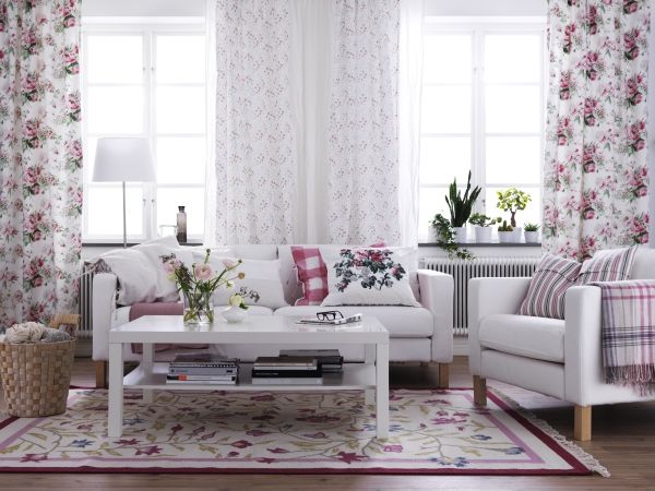 Soft and Feminine IKEA Living Room. White earthy neutrals and updated versions of florals gives this living space a fresh and feminine feel. White and soft sofas, white coffee table really work with the floral and beautiful curtains.