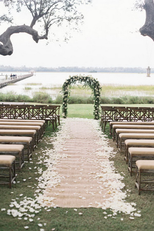 Classic Floral Arch with Petal Burlap Wedding Aisle Runner
and Linen-Upholstered Wooden Benches