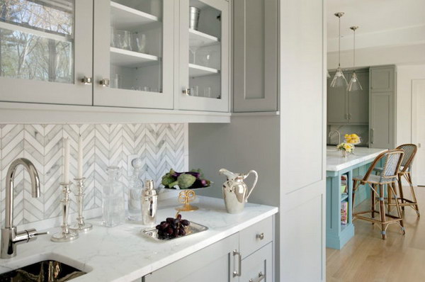 Marble-Tiled Chevron Backsplash with Light Grey Cabinetry 