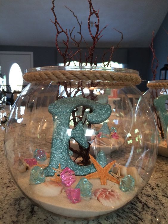 Seashells And Sand Displaying In A Fish Bowl. 